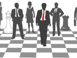 13831980 - moving business man leads team to win as pieces on chess board