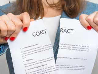 Business woman tearing contract in office - breaking contract